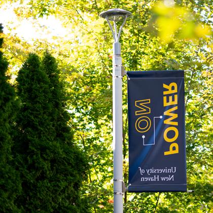 A Power On sign hangs on a lightpole on campus.